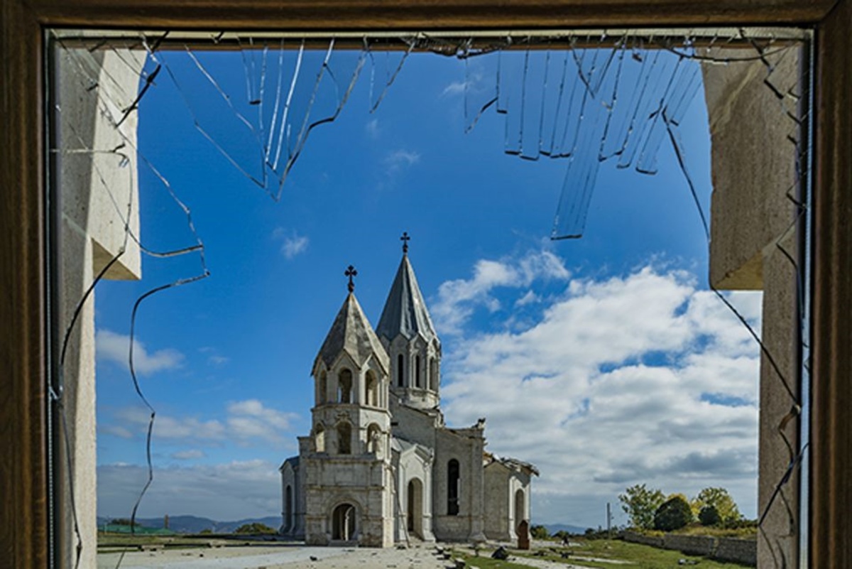 Blick durch ein geborstenes Fenster aus einem Gebäude in der Nähe der Kathedrale von Schuschi, der Ghazantschezoz-Kathedrale, nachdem durch einen aserbaidschanischen Doppeltreffer am 11. Oktober 2020 ein Teil des Daches zerstört wurde. Foto: Celestino Arce/NurPhoto